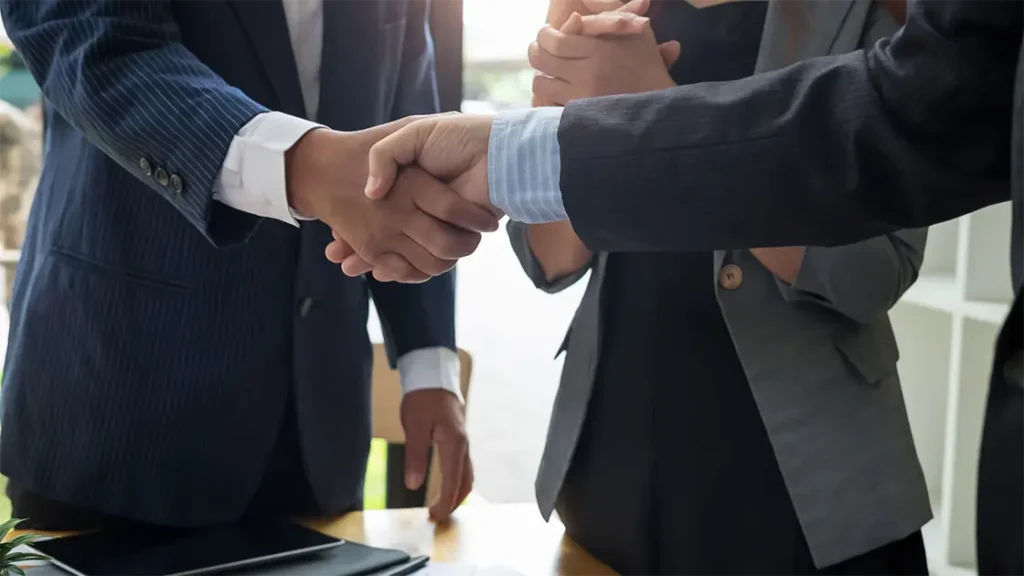 personas saludandose de mano en ambiente de negocios
