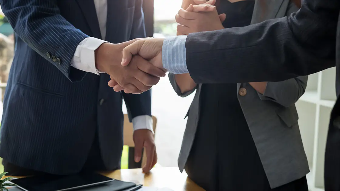 personas saludandose de mano en ambiente de negocios